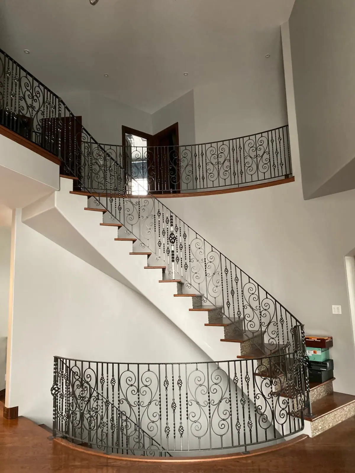 Bright curved staircase with a smooth freshly painted ceiling