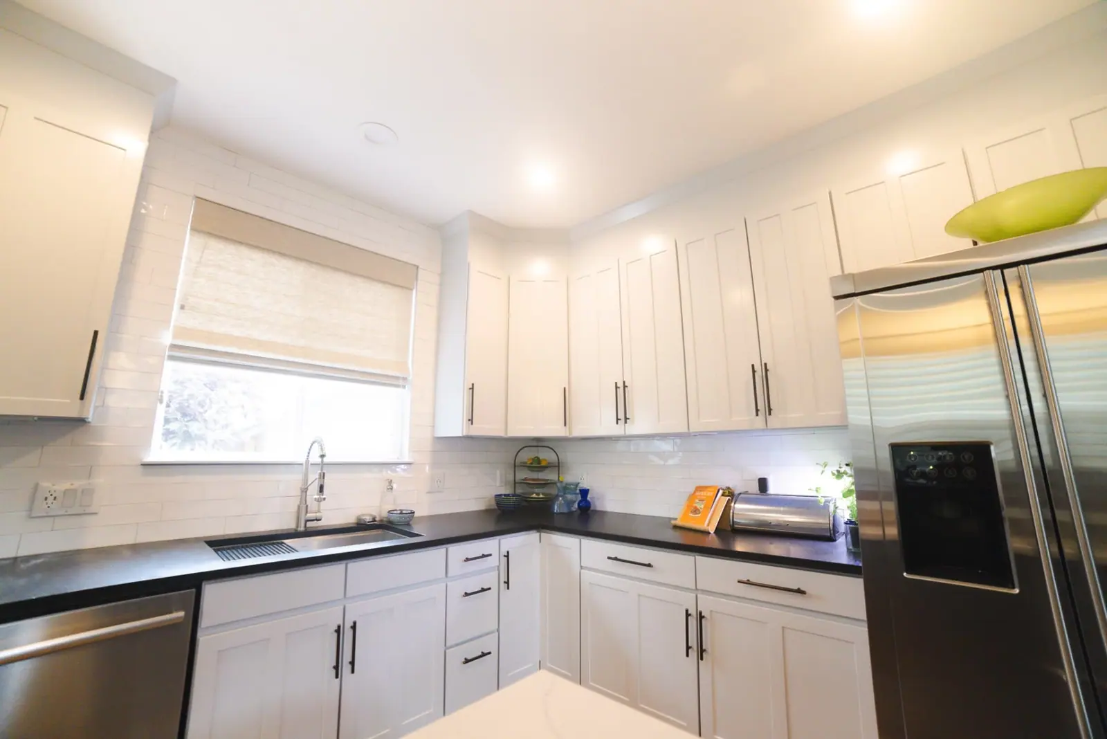 Bright white kitchen with black hardware and subway tile after painting
