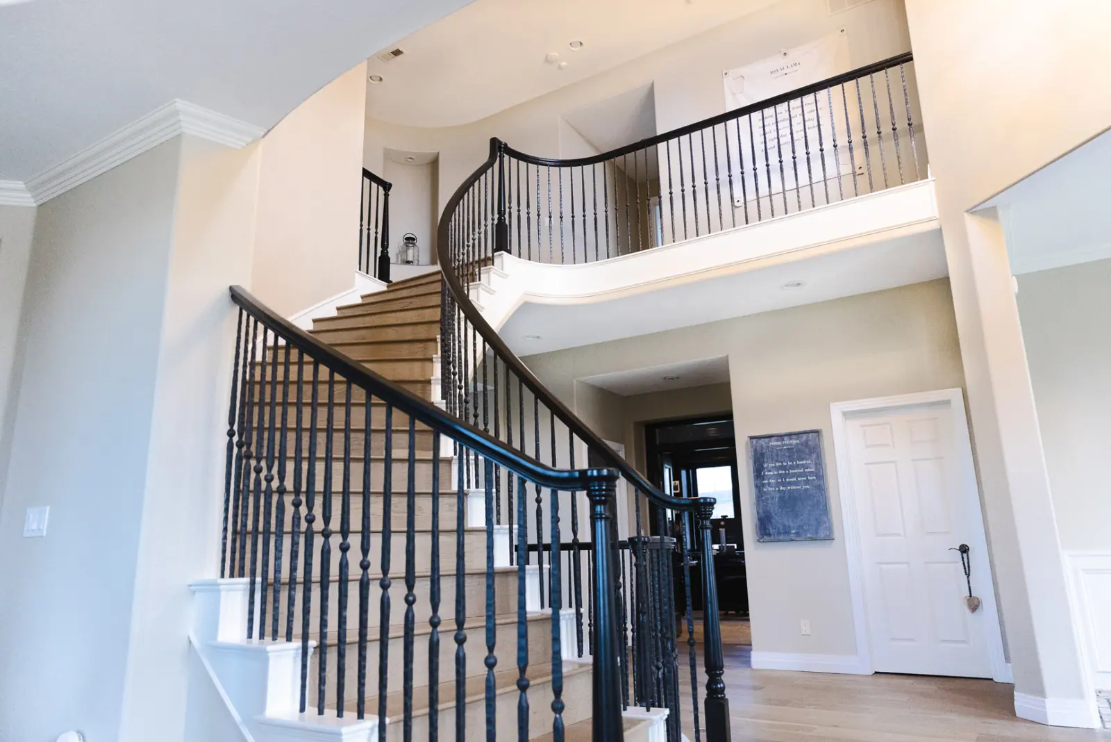 Two-story stairwell with black-painted railings and crisp white trim in Lone Tree