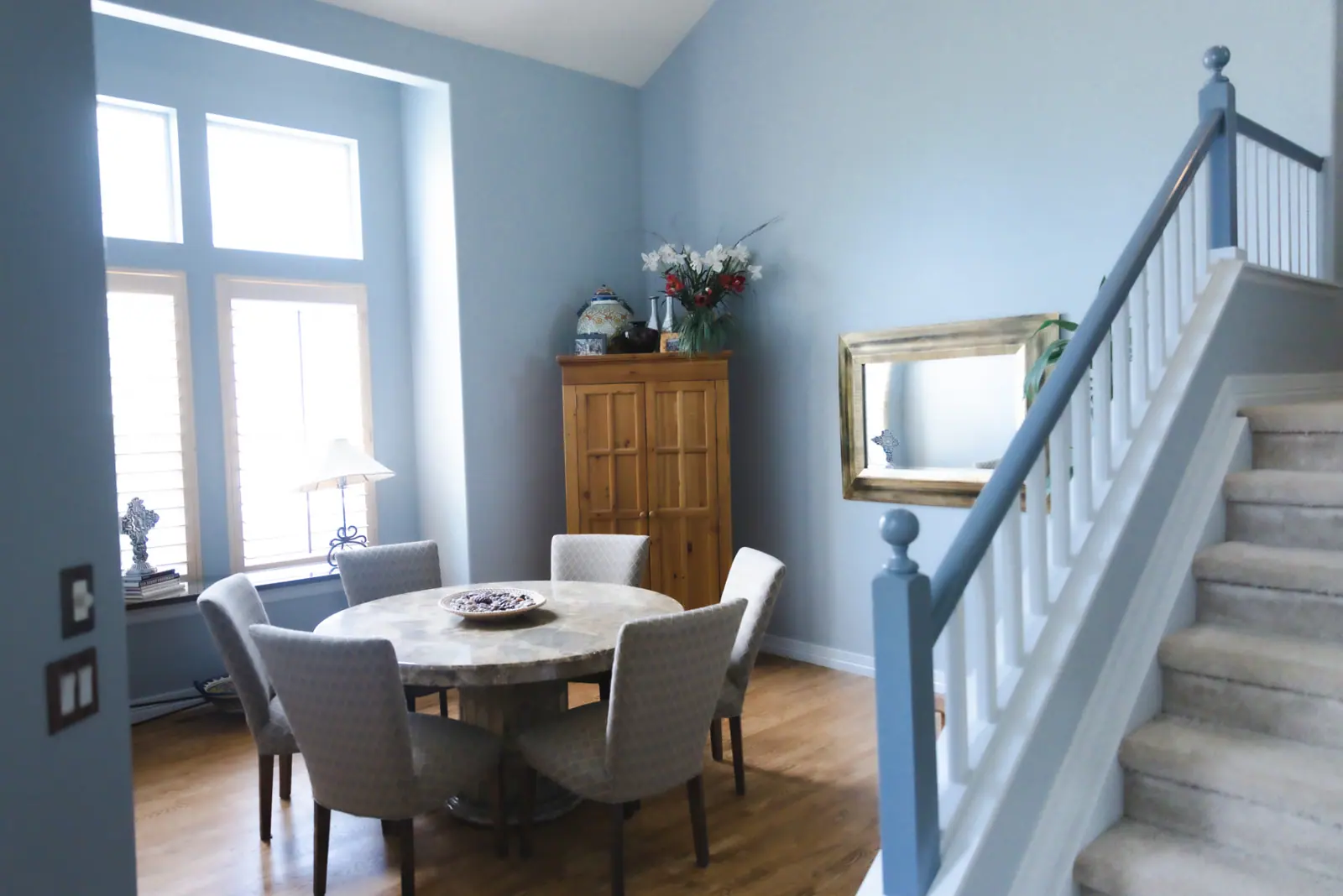 Dining area painted in a soft blue-gray with white trim